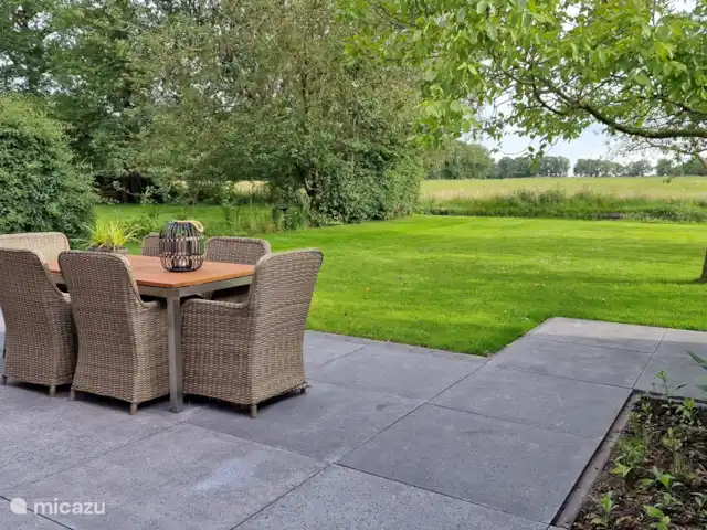 Uitzicht over weide en bosrand